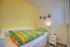 1 dormitorio con 1 cama con un edredón colorido en Ferienpark - Haus H, App 0H0707, en Heiligenhafen