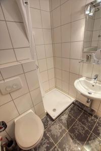 ein weißes Bad mit einem WC und einem Waschbecken in der Unterkunft Ferienpark - Haus H, App 0H0709 in Heiligenhafen