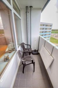 einen Stuhl auf einem Balkon mit einem Fenster in der Unterkunft Ferienpark - Haus H, App 0H0709 in Heiligenhafen