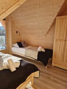 a bedroom with two beds in a log cabin at LITTLE KOIS VILLAGE in Dzianisz