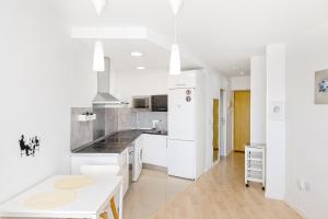 una cucina con armadi bianchi e piano di lavoro bianco di Sun Apartments a Torremolinos