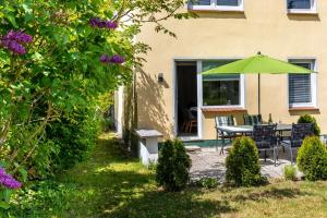 un patio avec une table et un parasol vert dans l'établissement Ferienwohnung "Sonnenschein", à Tarnewitz