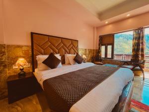 a bedroom with a large bed with a large window at The River Grand, Mussoorie in Mussoorie