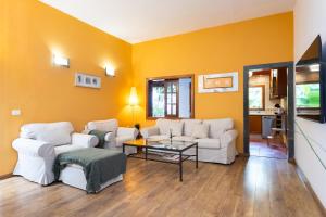 una sala de estar con muebles blancos y paredes amarillas. en Garachico Center Secret Garden en Garachico
