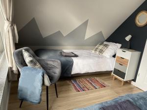 a bedroom with a bed and a chair in it at Przystanek Przylasek in Grywałd