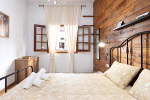 1 dormitorio con 1 cama grande y pared de madera en Garachico Center Secret Garden en Garachico