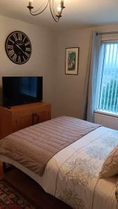 a bedroom with a large bed and a clock on the wall at Sunny Rooms near town centre in Warrenpoint