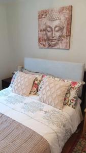 a bed with pillows and a painting on the wall at Sunny Rooms near town centre in Warrenpoint