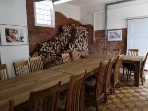 a large wooden table in a room with a stack of logs at Historischer Marktplatz in Spangenberg