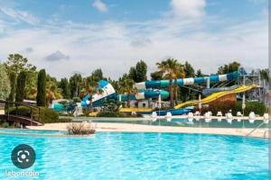 a pool at a resort with a water park at MOBILHOME FABULEUX CAMPING VIAS PLAGE - PISCINE et SPA - 4 ETOILES in Vias