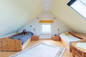 a attic bedroom with two beds and a table at Kleinwindstein in Neukirchen