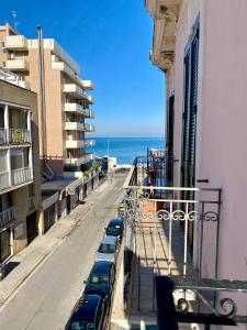 Una fila de autos estacionados en una calle al lado de un edificio en La Cementina sul mare, en Bari