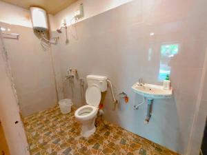 La salle de bains est pourvue de toilettes et d'un lavabo. dans l'établissement EcoZen Holiday Rooms, à Agonda