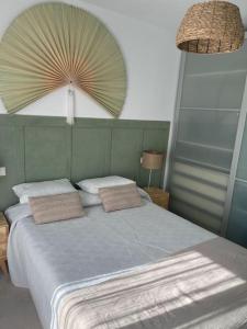 1 dormitorio con 1 cama con 2 almohadas y ventilador en Soleado y luminoso apartamento, en Fuengirola