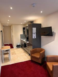 a living room with a couch and chairs and a kitchen at St Benedicts Apartments in Norwich