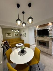 Una sala de estar con mesa y sillas y una chimenea. en Apartmani Lana, en Vlašić
