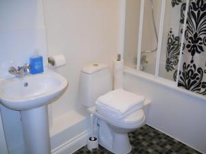 a bathroom with a white toilet and a sink at Citystay Guest House in London