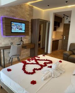 a bedroom with a bed with red flowers on it at Hotel Comfort & Villas in Donji Štoj