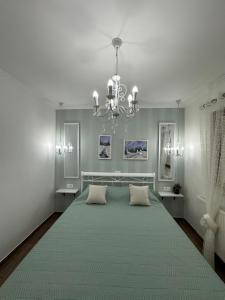 Un dormitorio con una cama grande con una lámpara de araña. en Apartmani Lana, en Vlašić 15 fotos más