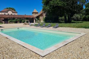 een zwembad met stoelen en een huis bij La Colombire Family House With Swimming Pool in Ratenelle
