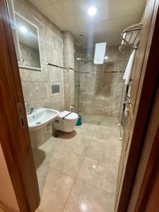 a bathroom with a shower and a sink and a toilet at Zümrüt Palas Otel in Erciyes