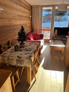 una sala de estar con una mesa con un árbol de Navidad. en Signal 308 apartment 6 person en Aime La Plagne