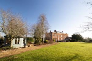 a house in the middle of a grassy field at Garden Wing, Redisham Hall in Beccles