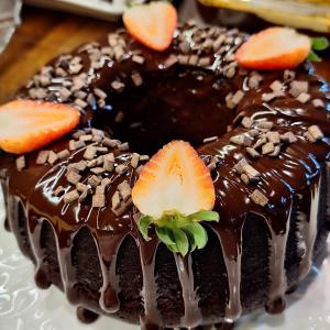 un pastel de chocolate con fresas en la parte superior de un plato en NAVEGA PRAIA HOTEL en Navegantes