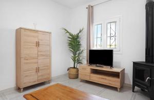 sala de estar con TV y armario de madera en Villa Montenmedio 1, en El Soto