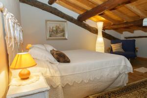 a bedroom with a bed and a table with a lamp at Casa Pini Rio_B in Riolunato