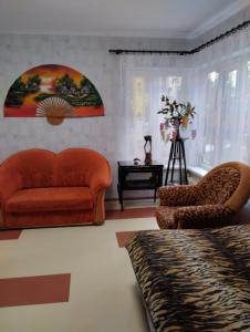 a living room with an orange couch and chairs at Jūrmala in Jūrmala