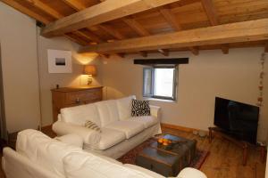 a living room with a white couch and a tv at Casa Pini Rio_B in Riolunato