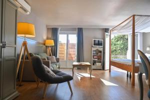 un soggiorno con letto, divano e sedia di La Lune De Mougins - Hotel & Spa a Mougins