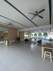 a large room with a ceiling fan and tables at Condotel Minimalist in Marilao