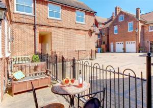 a patio with a table and chairs and a fence at Happy Days in Southwold