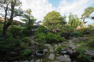 ogród z kamieniami i drzewami oraz dom w obiekcie furano ski rabi w mieście Furano