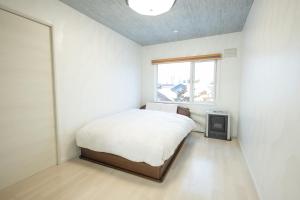 a bedroom with a bed and a tv in it at furano ski rabi in Furano
