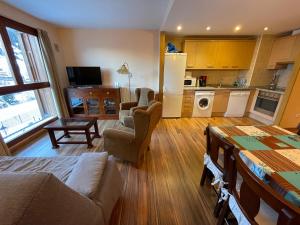 a living room with a couch and chairs and a kitchen at Soldeu Paradis Pleta 2 in Soldeu