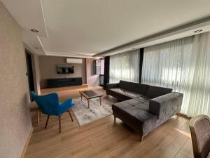 Şehrar Suite Hotel في طرابزون: غرفة معيشة مع أريكة وكرسي أزرق