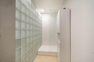 a walk in shower in a bathroom with a glass door at Kokořín Apartments in Kokořín