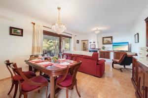 a living room with a table and a red couch at Villa Manresa in Alcudia by JS Villas in Alcudia