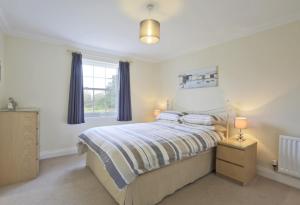 um quarto com uma cama com duas almofadas e uma janela em Jubilee View em Southwold