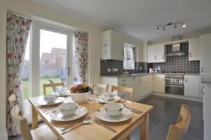 a kitchen with a table with a bowl of fruit on it at Jubilee View in Southwold