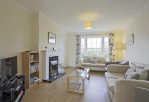 a living room with a couch and a fireplace at Jubilee View in Southwold