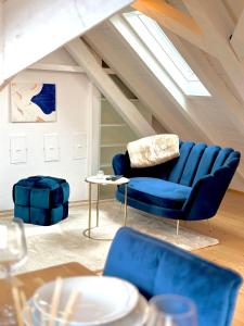 a living room with a blue couch and a table at Zentrale Wohnung mit Dachterasse in Bregenz