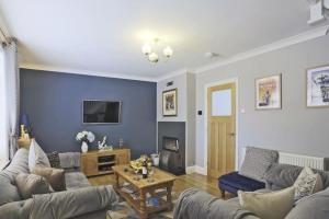 a living room with a couch and a table at Little Blue Cottage in Southwold
