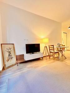 een woonkamer met een flatscreen-tv en een tafel bij nuovo appartamento a due passi dal centro in Turijn