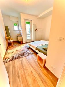 um quarto com uma cama e piso em madeira em nuovo appartamento a due passi dal centro em Turim