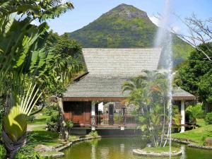 ein Haus mit einem Brunnen inmitten eines Teiches in der Unterkunft Sofitel Mauritius L'Imperial Resort & Spa in Flic-en-Flac