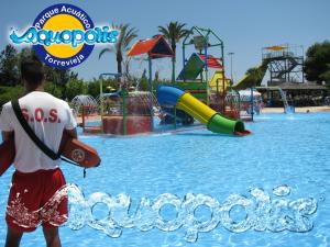 ein Mann, der in einem Wasserpark im Wasser steht in der Unterkunft Homely Apartments Vitoria in Torrevieja